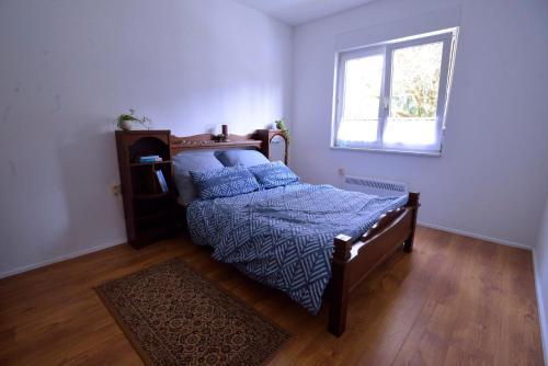 SeligenthalFerienpark Ebertswiese的一间卧室配有一张带蓝色棉被的床和窗户。