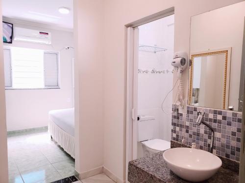 卡舒埃拉保利斯塔Pousada Boa Vista的白色的浴室设有水槽和镜子