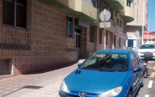 厄尔梅达诺El Medano - Cerca de la Playa的停在街道边的蓝色汽车