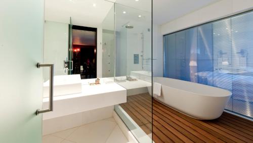 查韦斯查韦斯赌场酒店的一间带两个盥洗盆、一个浴缸和玻璃墙的浴室