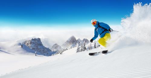 格雷索圣尚格兰白塔酒店的一个人在雪覆盖的斜坡上滑雪