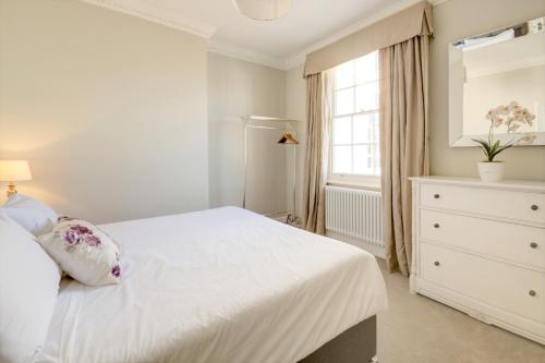切尔滕纳姆Wolcote House的白色的卧室设有白色的床和窗户。
