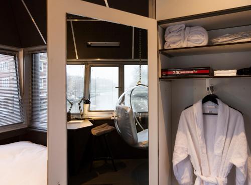 阿姆斯特丹SWEETS - Wiegbrug的更衣室配有浴袍、床和书桌