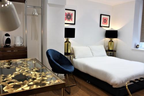 格拉茨克洛斯瑞欧司乔治公寓式酒店的酒店客房设有一张床铺和一张玻璃桌