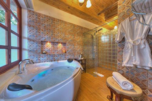 伊瓦拉卡罗拉维庄园酒店的大型浴室设有浴缸和淋浴。
