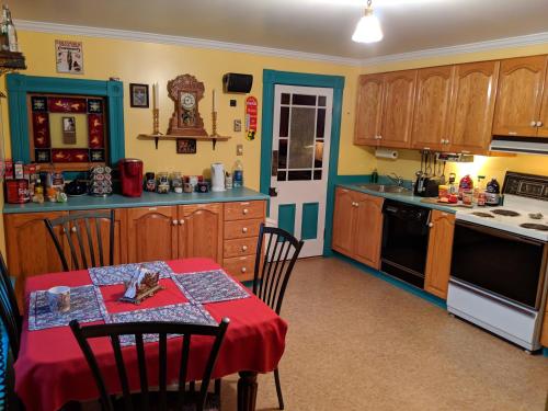 圣约翰斯Gower Manor Historic Bed & Breakfast的厨房配有一张带红色桌布的桌子