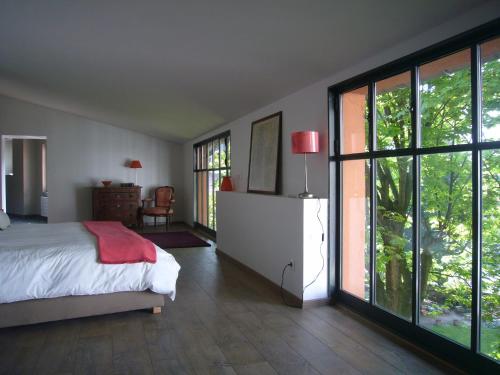 里昂博瓦尔花园酒店的一间卧室设有床和滑动玻璃门