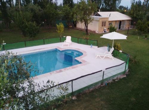Coquimbito特拉奥利沃小屋酒店的一个带两把椅子和遮阳伞的游泳池
