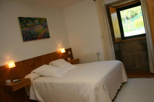 艾斯特拉达Casa rural A Mimoseira的卧室配有白色的床和窗户。