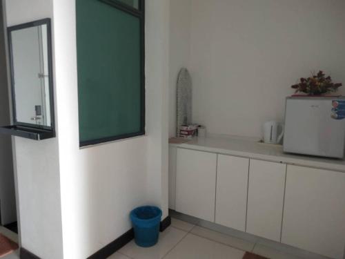 波德申DWharf Port Dickson (Private Condo)的厨房配有白色橱柜和绿色窗户。
