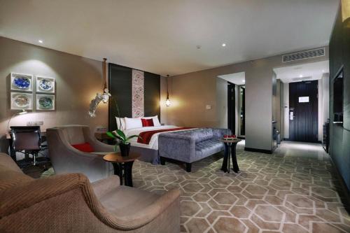 雅加达ASTON Priority Simatupang Hotel and Conference Center的酒店客房,配有床和沙发