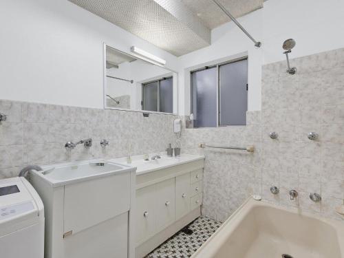 安特兰斯海豚苑5号公寓的白色的浴室设有浴缸、水槽和镜子