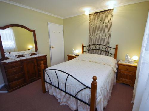 图克雷弗兰温度假屋的一间卧室配有一张床、梳妆台和镜子
