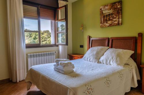 Porrúa艾尔坡拉伊格莱西亚乡村民宿的一间卧室配有一张床,上面有两条毛巾