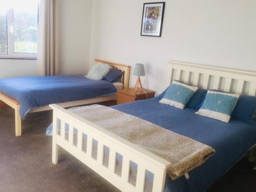 米尔敦马尔贝Cosy Apartment的一间卧室配有两张蓝色床单