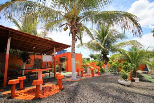 奥林匹亚Pousada Sol Nascente的棕榈树建筑前的一排橘色长椅