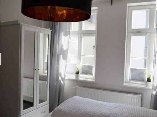 戈斯拉尔Zum Jakobi 1的一间卧室配有一张床、窗户和吊灯