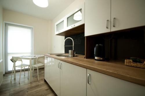 比得哥什Dream Team Pomorska的厨房配有白色橱柜和一张带窗户的桌子