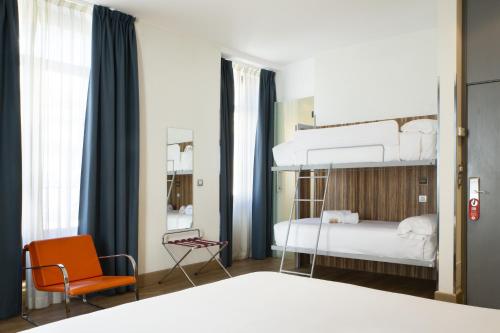 马德里卡门广场小宫殿酒店的一间卧室配有两张双层床和椅子