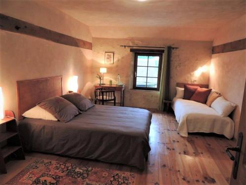 Rémalardla Maison des Aubées的一间卧室配有两张床和一张桌子
