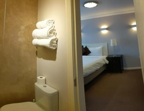 威廉堡麦克莱恩旅馆的一间带卫生间的浴室和一张带毛巾的床