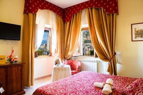 Arpino达皮诺伊尔骑士酒店的一间卧室配有红色的床、椅子和窗户