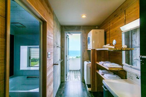 石垣岛"NICE!" Ocean view of Ishigaki island, Okinawa/ Four-bedroom Villa的带浴缸、水槽和窗户的浴室