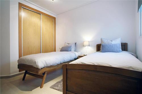罗尔丹Casa Buena Vista的一间卧室配有两张床和一个带灯的床头柜