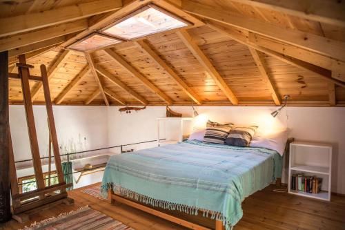 米利纳Piges的一间带一张床的卧室,位于带木制天花板的房间内