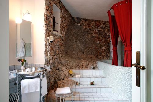 马拉泰亚洛坎达酒店的一间带水槽和石墙的浴室