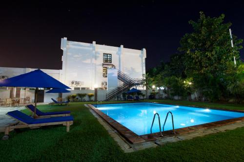 帝力提摩尔酒店的一座游泳池,在晚上在建筑物前