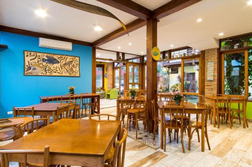乌巴图巴Pousada Peixes do Mar的餐厅设有木桌和椅子,拥有蓝色的墙壁