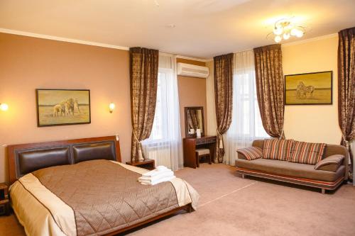奇姆肯特图腾酒店的一间卧室配有一张床和一张沙发