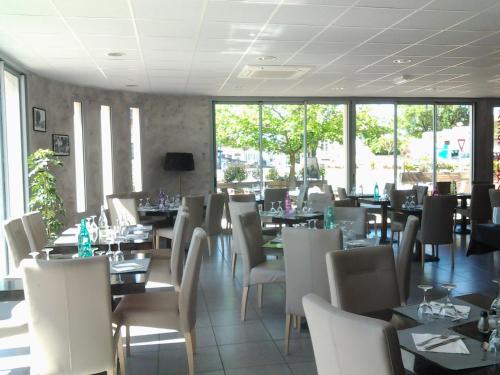 Montaigu-de-Quercy迷笛酒店的用餐室设有桌椅和窗户。