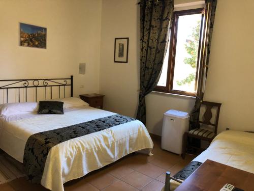 锡耶纳锡耶纳托斯卡纳旅馆的一间卧室设有两张床和窗户。