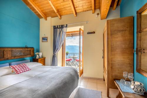 坎诺比奥阿蒂利奥乡村酒店的一间卧室设有一张床,并有通往阳台的门