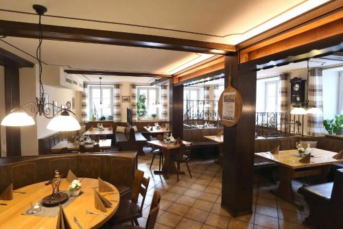 索梅劳森金牛葡萄园宾馆的餐厅设有木桌、椅子和窗户。