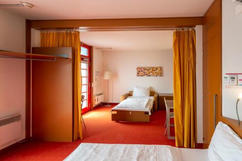 多瑙河畔克雷姆斯橙色翅膀克雷姆斯酒店的一间酒店客房,设有一张床和一张床,还有一间卧室