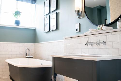 沃辛The Highdown – Brunning and Price的带浴缸、水槽和镜子的浴室