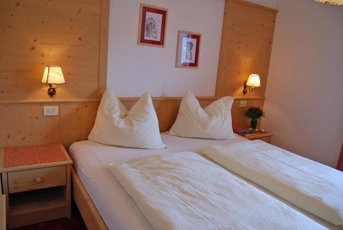 布列瑟农韦德曼斯霍夫酒店的一间卧室配有两张带白色床单和枕头的床。