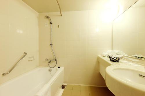 神户Hotel Konigs-Krone Kobe的白色的浴室设有水槽、浴缸和淋浴。