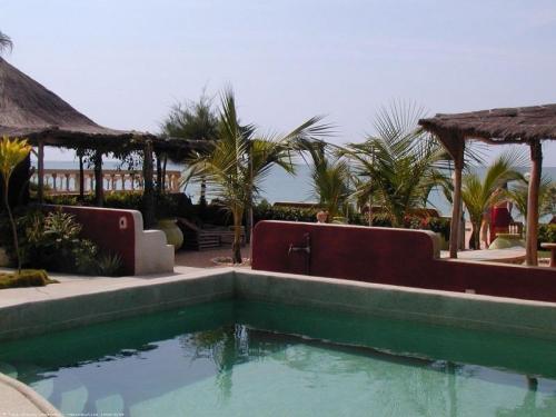 萨利波图尔科尔玛雅公寓式酒店的棕榈树度假村前的游泳池