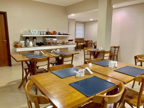 阿拉萨图巴Hotel Flat Alameda的用餐室配有木桌和椅子