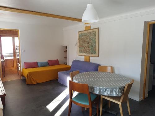 布里昂松Appartement RDC chalet 55m2的客厅配有桌子和床。