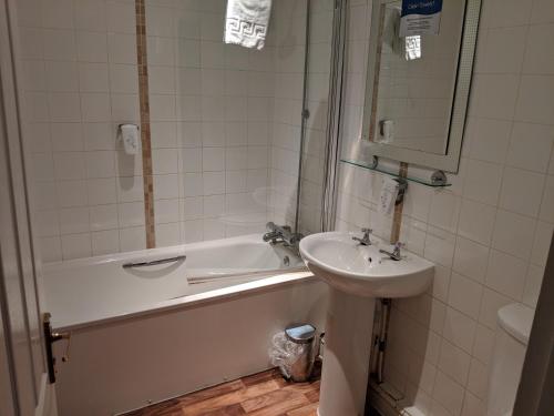 安德沃White Hart, Andover by Marston's Inns的浴室配有盥洗盆、浴缸和盥洗盆