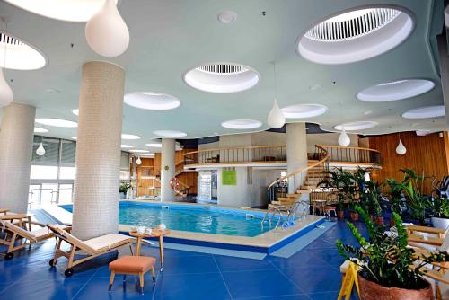布加勒斯特Grand Hotel Bucharest的一座带椅子的游泳池和一座游泳池