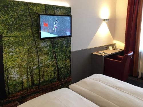 富尔达德姆酒店的配有电视、床和窗户的酒店客房