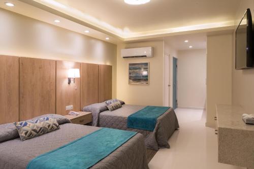 埃莫西约La Siesta Hotel的酒店客房设有两张床和一台平面电视。