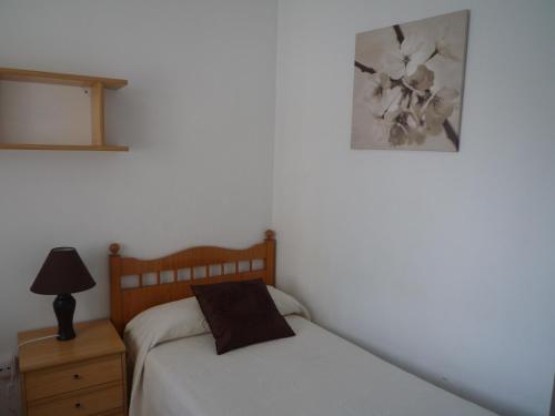 卢戈彭特维拉旅馆的卧室配有一张床,墙上挂着一幅画