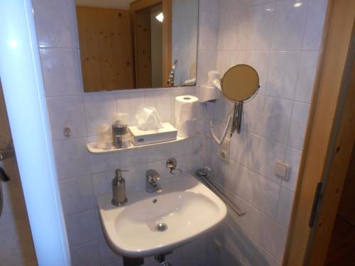 卑尔根Restaurant Olympia & Apartments的一间带水槽和镜子的浴室